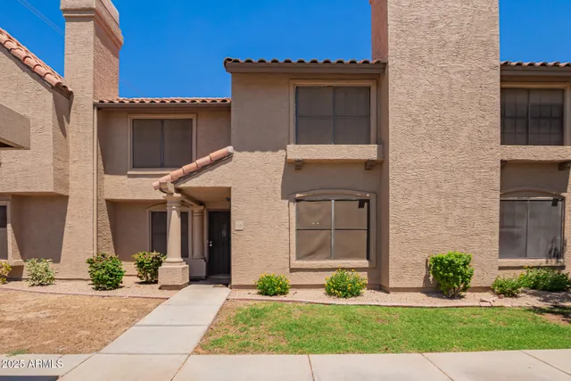 a front view of a house with a yard and outdoor seating