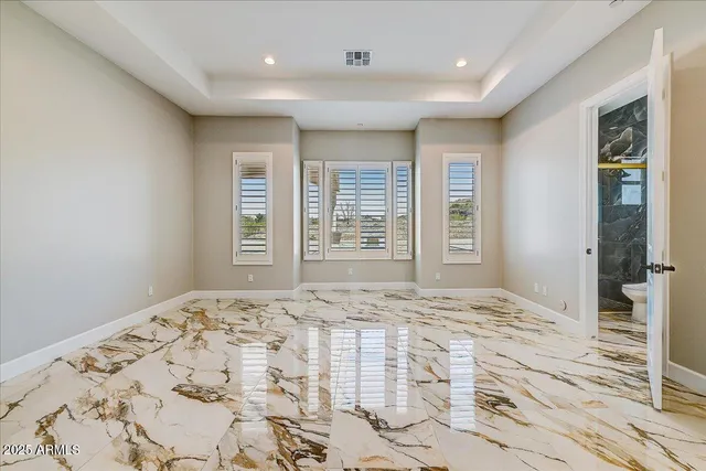 a view of a bedroom with a bed and wooden floor