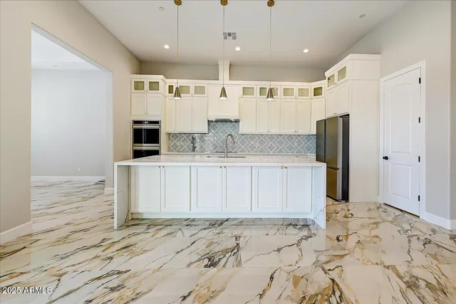 a large kitchen with stainless steel appliances kitchen island granite countertop a sink and cabinets