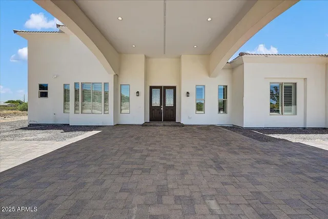 a view of an empty room with wooden floor and a kitchen