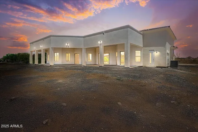 a view of a white house with a large space