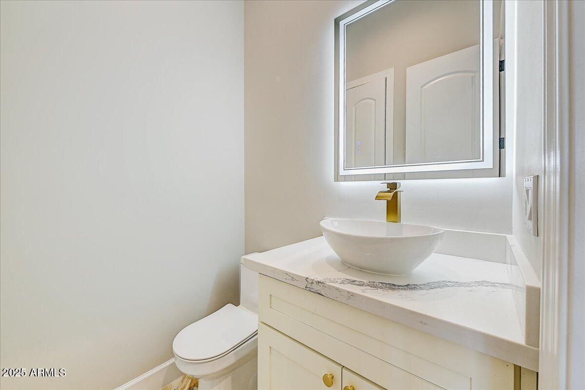 27730 North 35th Avenue Phoenix, AZ 85083 - Photo 7 of 37 a bathroom with a granite countertop toilet a sink and mirror