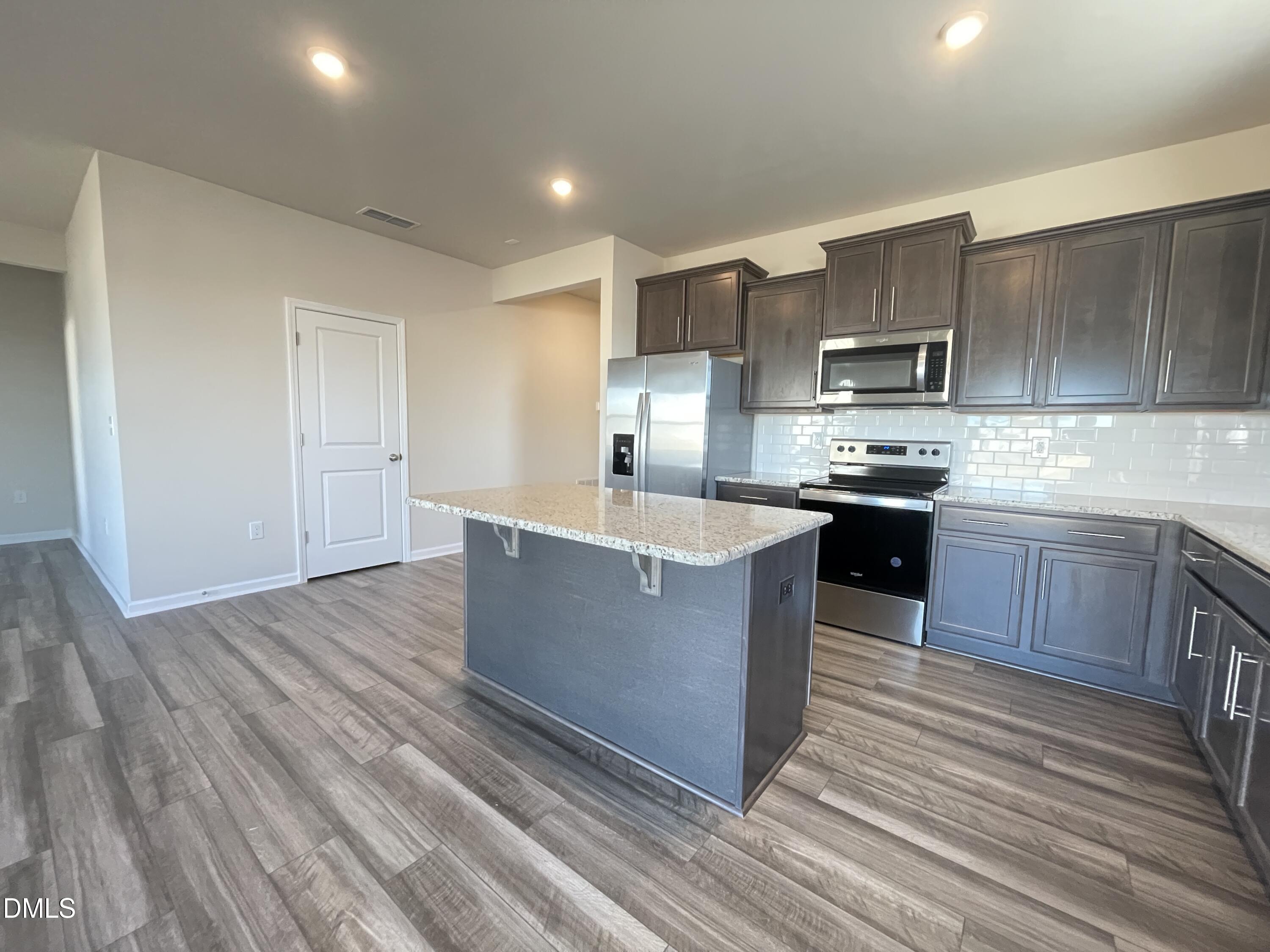 3521 New Town Road Raleigh, NC 27604 - Photo 9 of 29 a large kitchen with stainless steel appliances wooden floors and wooden cabinets