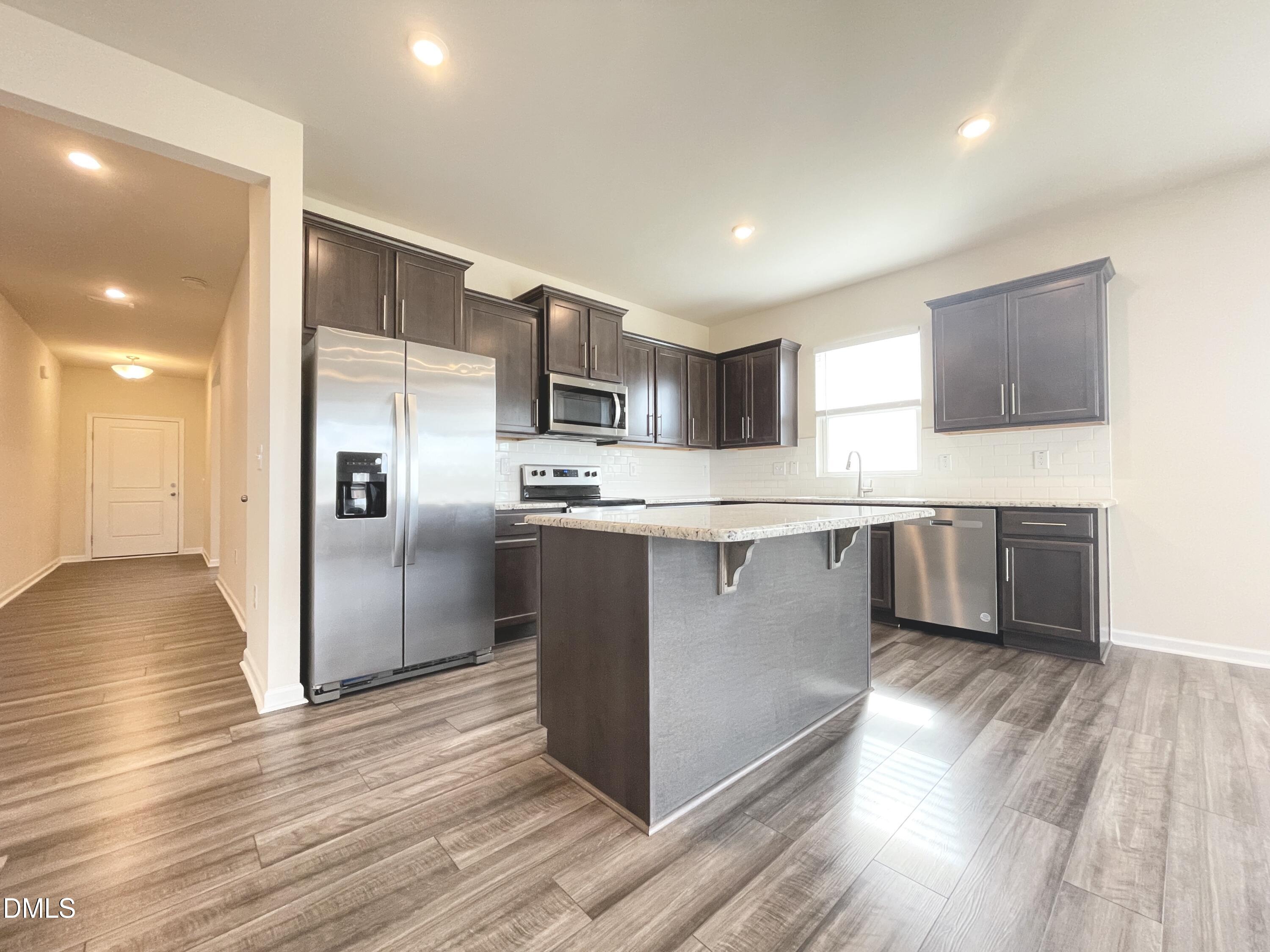 3521 New Town Road Raleigh, NC 27604 - Photo 10 of 29 a large kitchen with stainless steel appliances granite countertop a stove a sink and a refrigerator
