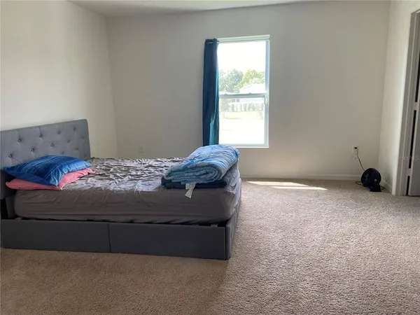 a bedroom with a bed and a window
