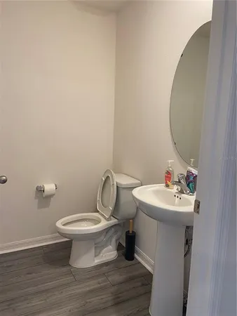 a bathroom with a sink toilet and a mirror