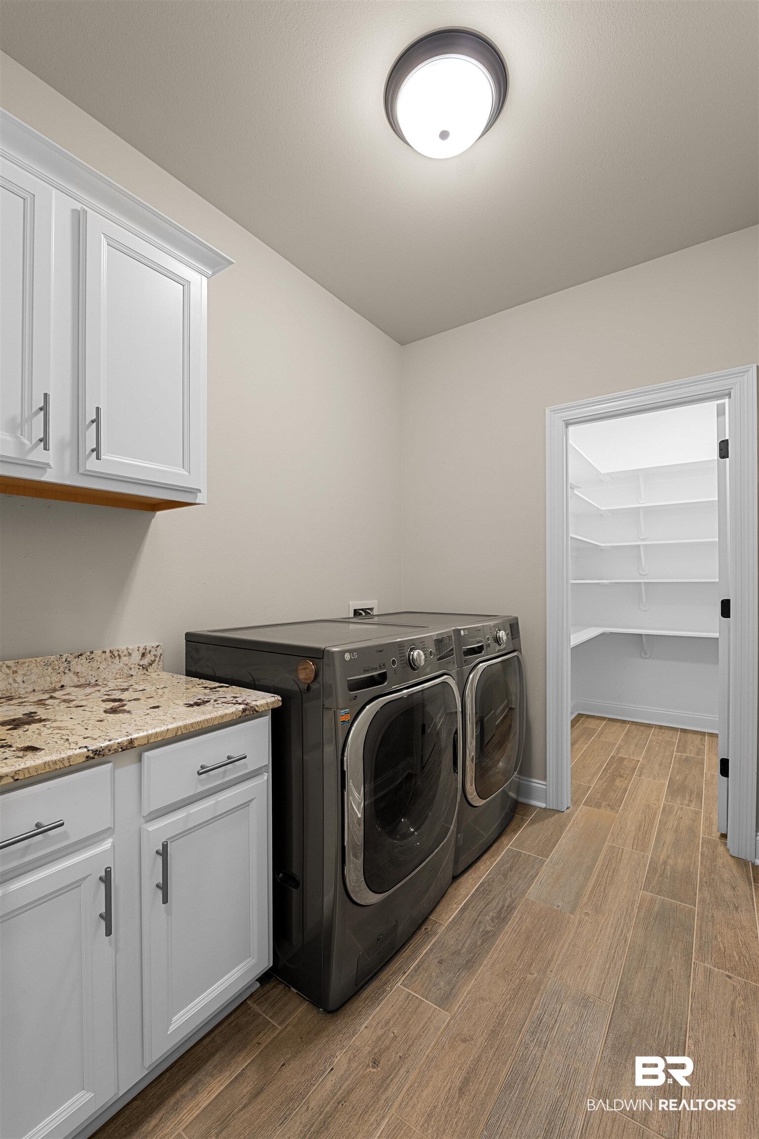 991 Dalton Circle Foley, AL 36535 - Photo 25 of 35 Laundry area with washer and clothes dryer, light wood-type flooring, and cabinet space