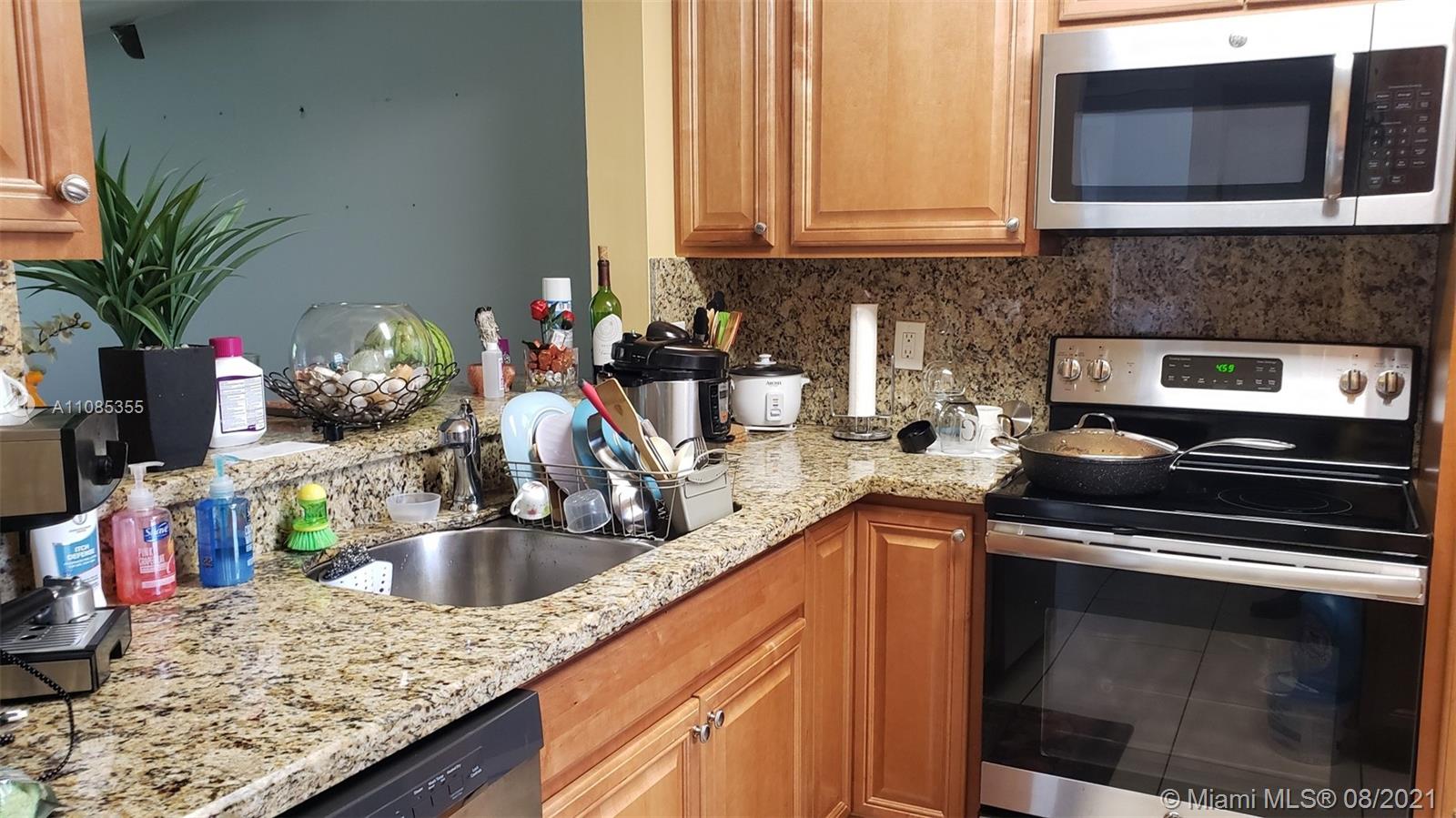 14857 Southwest 104th Street, Unit 9205 Miami, FL 33196 - Photo 4 of 11 a kitchen with stainless steel appliances granite countertop a sink stove and microwave
