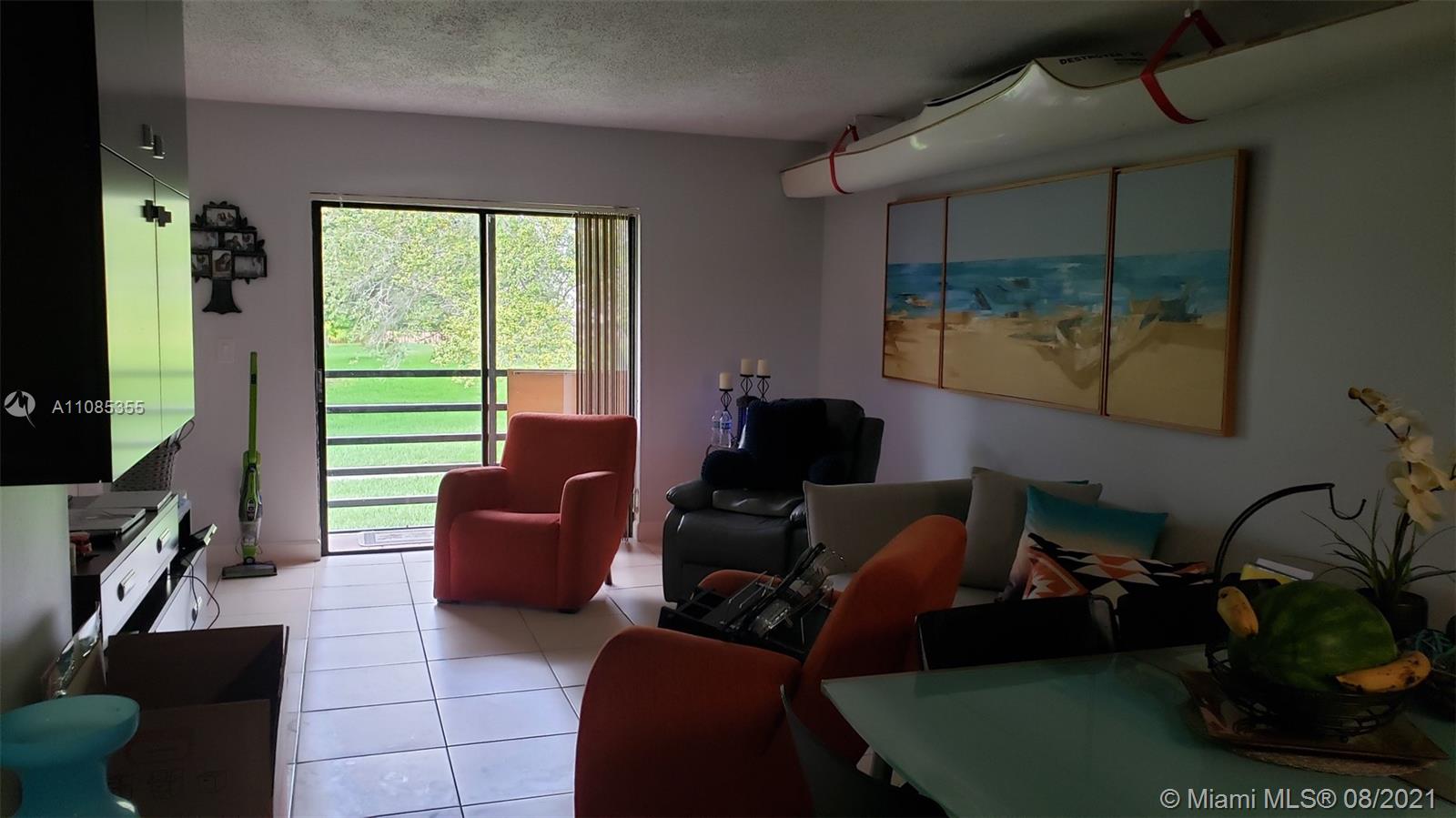 14857 Southwest 104th Street, Unit 9205 Miami, FL 33196 - Photo 8 of 11 a living room with furniture a flat screen tv and a window