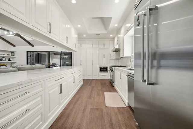 a large white kitchen with stainless steel appliances