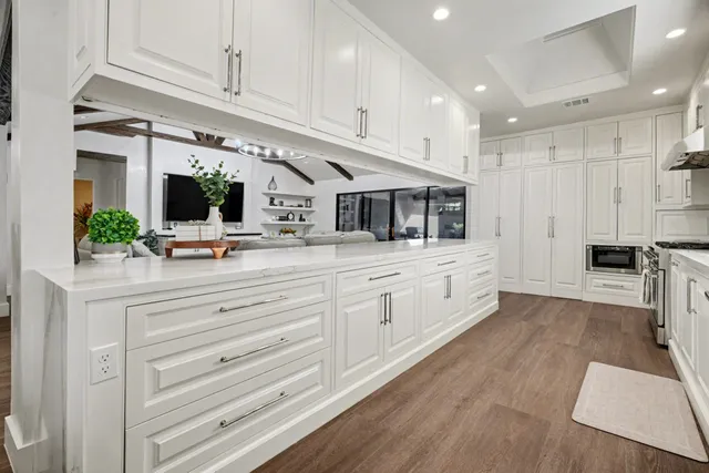 a kitchen with stainless steel appliances kitchen island granite countertop a refrigerator and a stove top oven