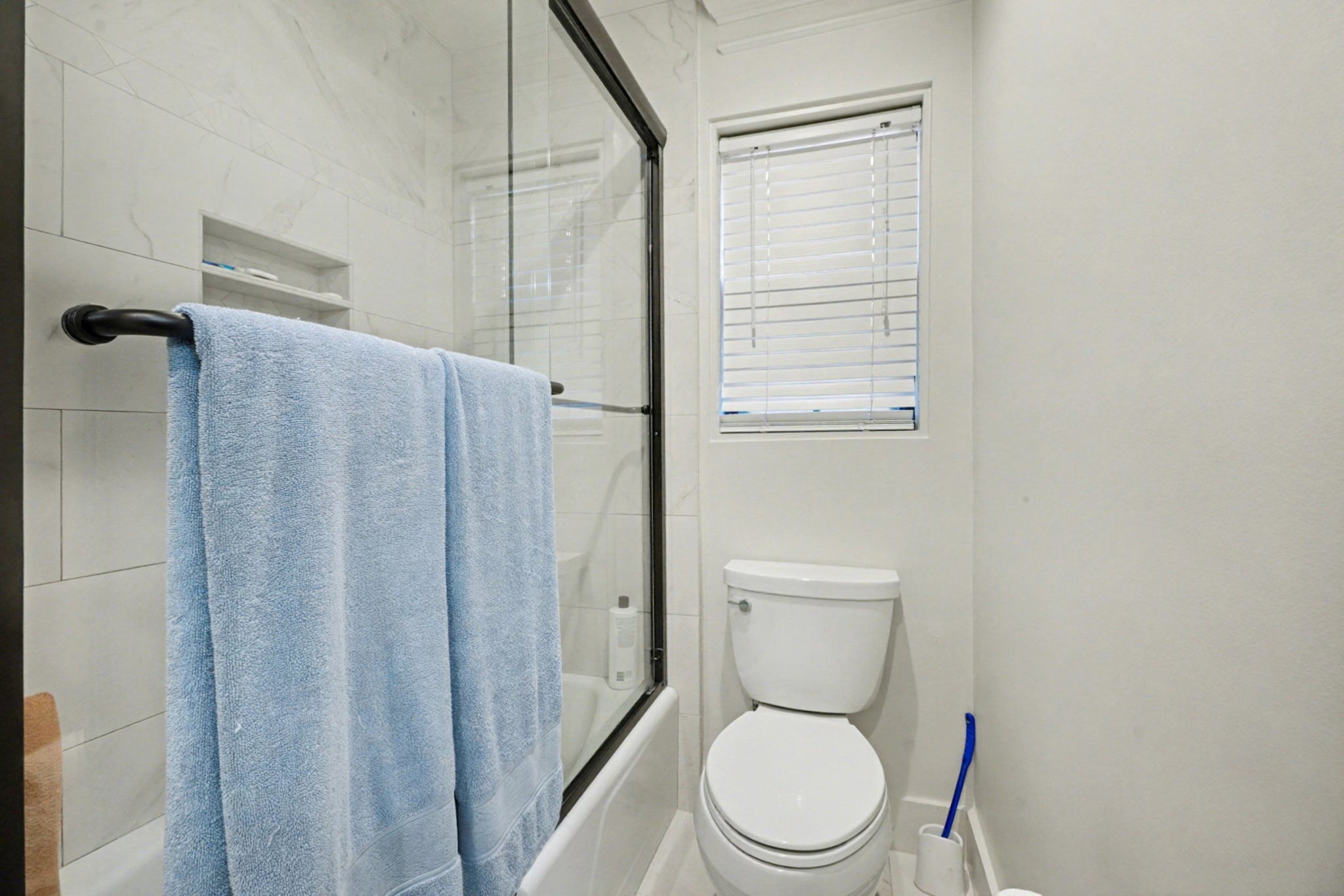 8515 Edgemoor Drive Houston, TX 77036 - Photo 28 of 33 a white toilet sitting next to a shower curtain