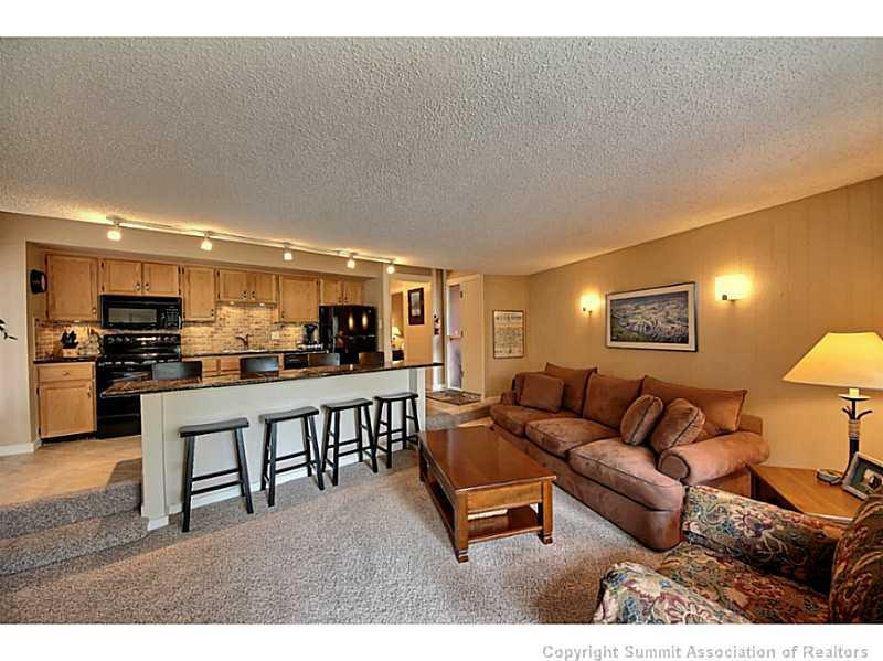 1100 Ski Hill Road, Unit 36 Breckenridge, CO 80424 - Photo 3 of 17 a living room with furniture a kitchen view and a kitchen island