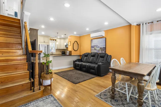 a living room with furniture kitchen view and a large window