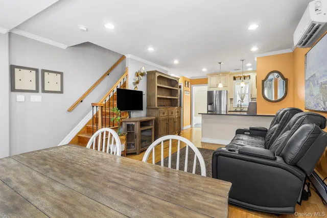 a living room with stainless steel appliances furniture and a rug