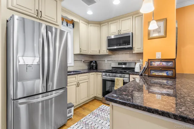 a kitchen with stainless steel appliances a stove a microwave a sink and cabinets