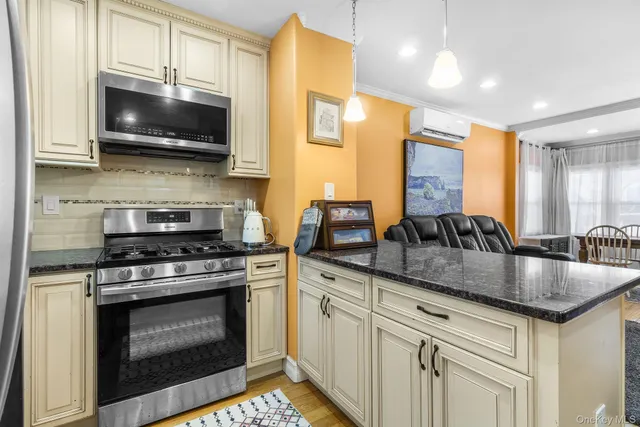 a kitchen with stainless steel appliances granite countertop white cabinets a stove a sink and dishwasher