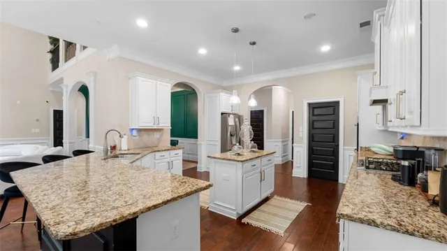 a kitchen with granite countertop kitchen island sink stove and refrigerator