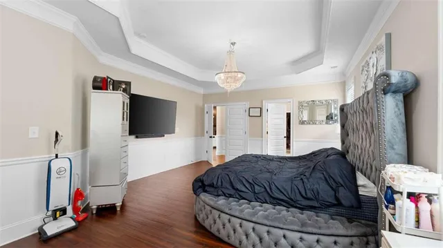 a spacious bedroom with a bed and a flat screen tv