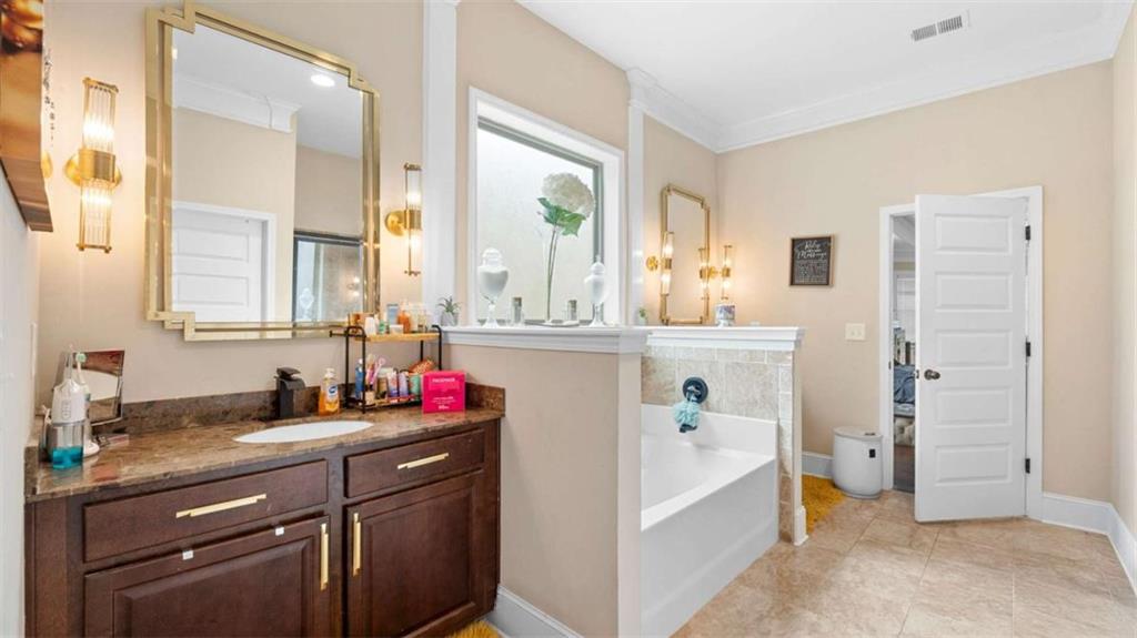 2328 Austin Common Way Dacula, GA 30019 - Photo 25 of 52 a bathroom with a tub sink and mirror