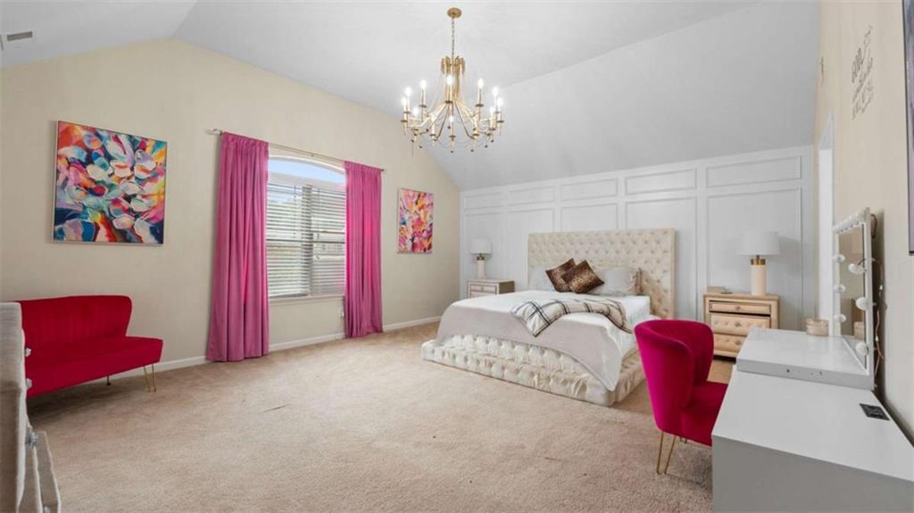 2328 Austin Common Way Dacula, GA 30019 - Photo 33 of 52 a bedroom with a bed and a chandelier