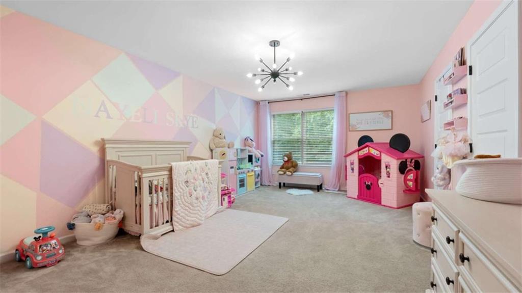 2328 Austin Common Way Dacula, GA 30019 - Photo 39 of 52 a bedroom with furniture and a chandelier