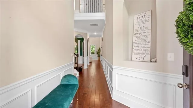 a view of a hallway with wooden floor and staircase