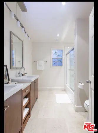 a spacious bathroom with a granite countertop sink a toilet and a shower