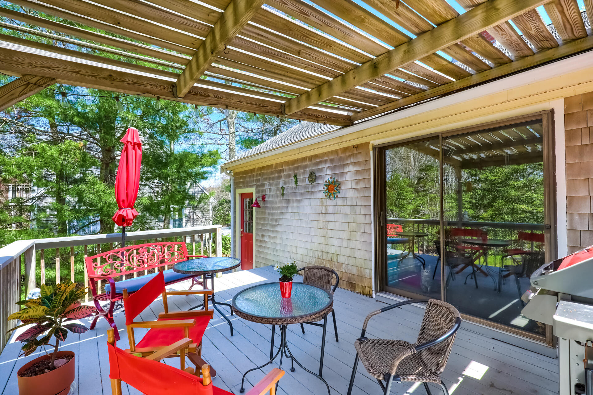 48 Gunstock Road Osterville, MA 02655 - Photo 25 of 28 a patio with a patio table and chairs with potted plants
