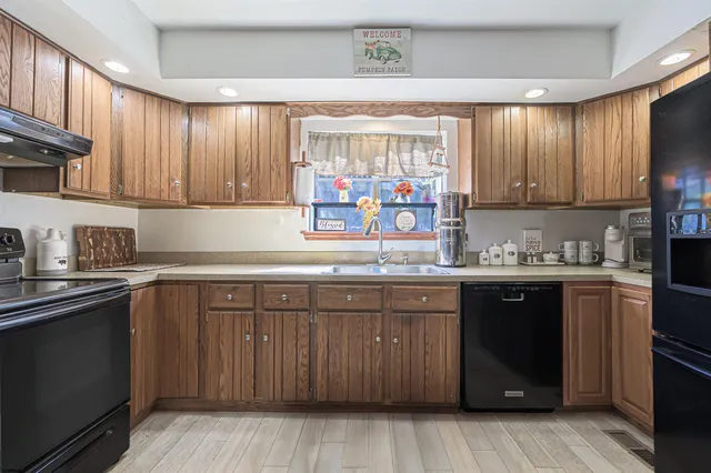 a kitchen with stainless steel appliances granite countertop wooden cabinets a sink and dishwasher