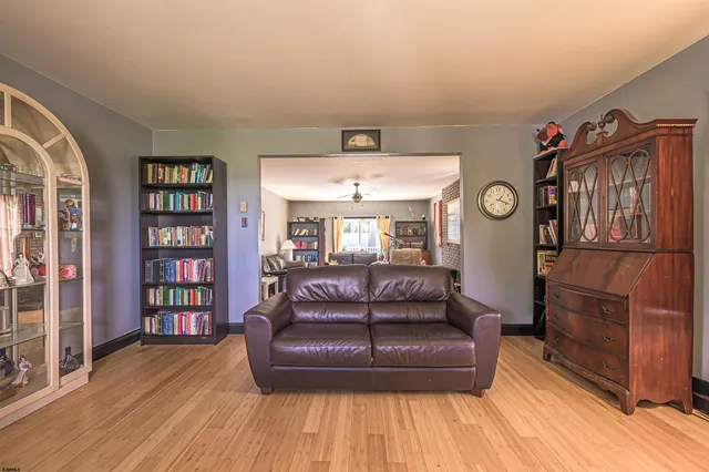 a living room with a couch and a bookshelf with wooden floor