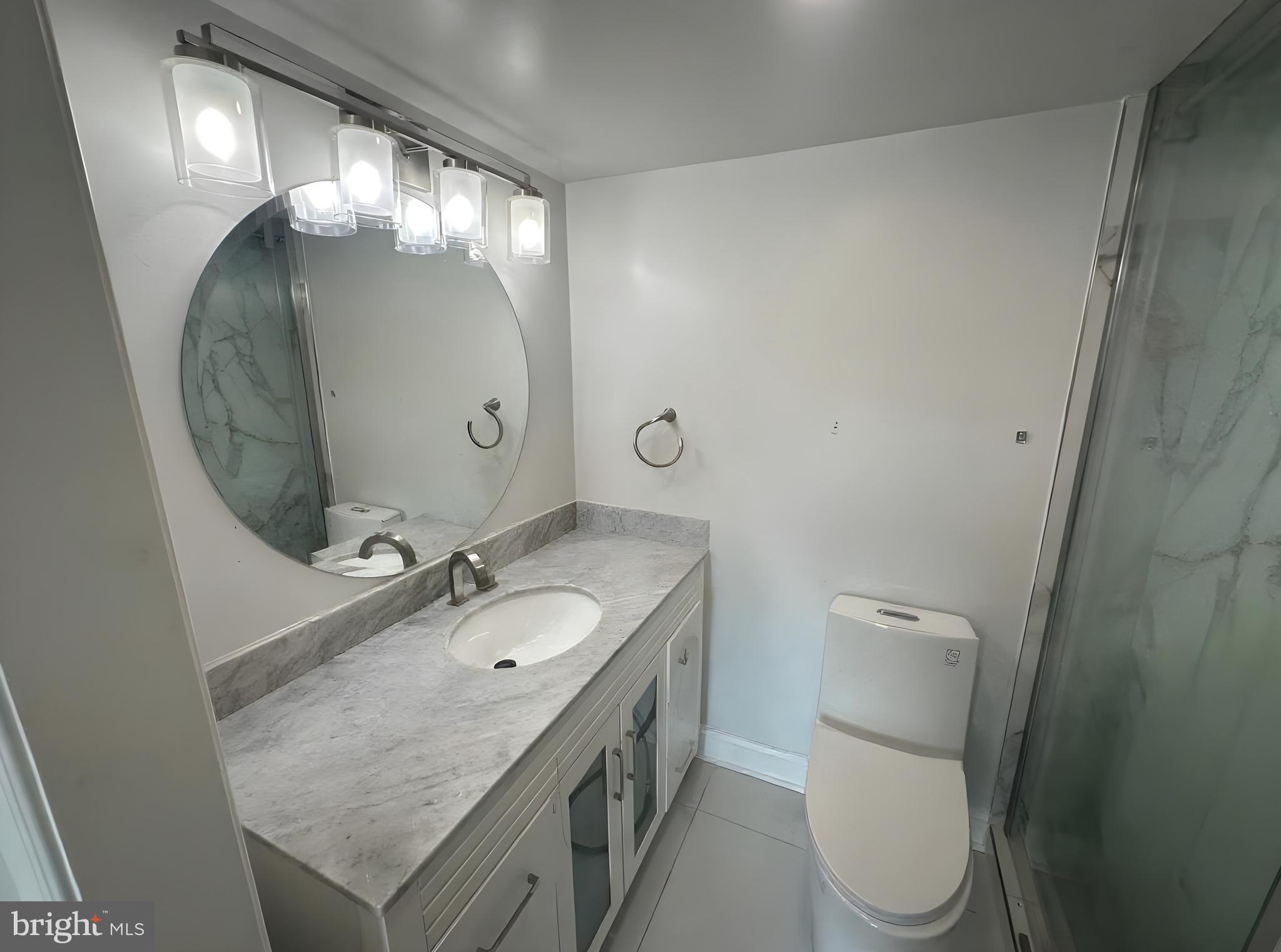 8350 Greensboro Drive, Unit 517 McLean, VA 22102 - Photo 15 of 35 a bathroom with a granite countertop sink a toilet and a mirror