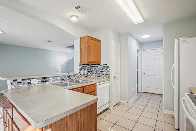 a view of a kitchen cabinets a sink a window and a refrigerator