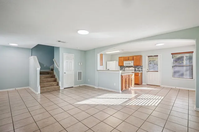 a view of a kitchen with wooden cabinets and entryway