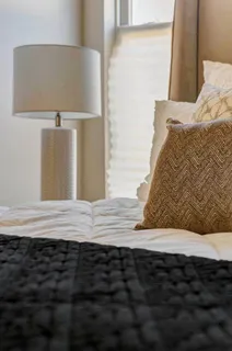 a large bed sitting in a bedroom next to a window
