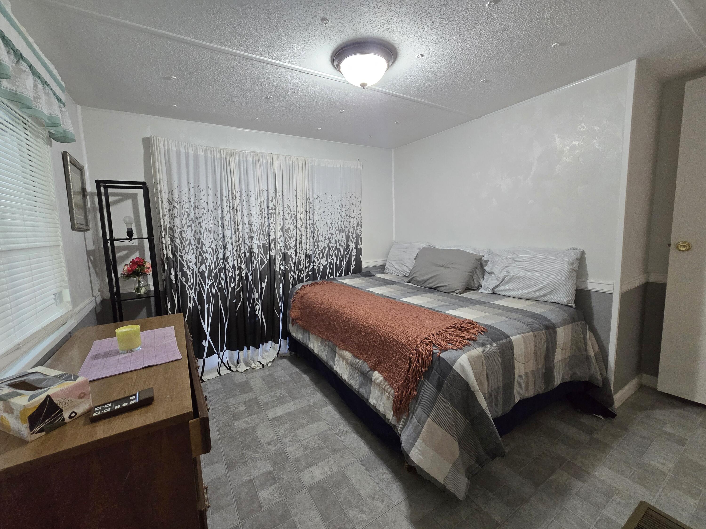 2612 Southeast 29th Street Okeechobee, FL 34974 - Photo 25 of 46 a bedroom with a bed a flat screen tv and a large mirror