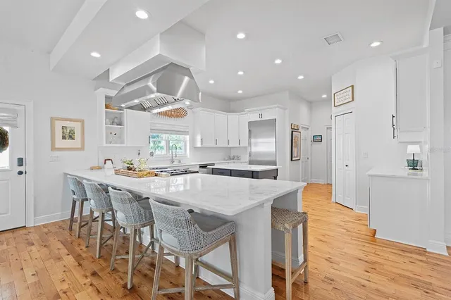 a kitchen with stainless steel appliances cabinets and wooden floor