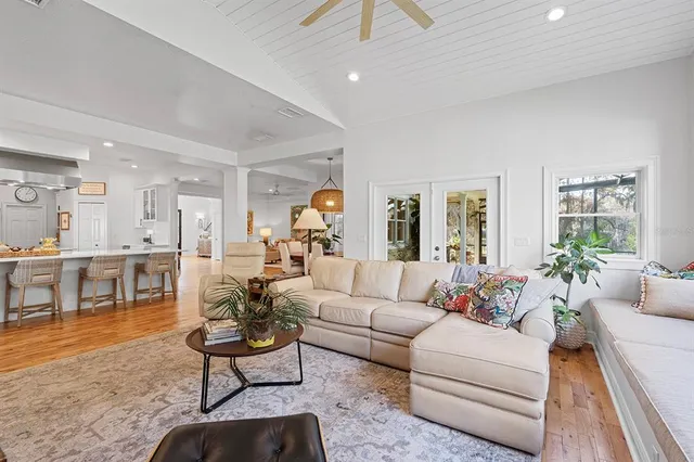 a living room with furniture two window and a flat screen tv