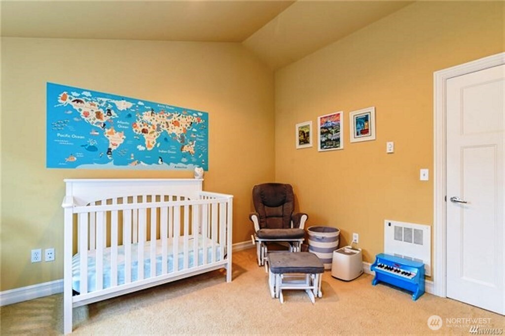 725 North 95th Street, Unit C Seattle, WA 98103 - Photo 9 of 18 a bedroom with furniture and a baby crib