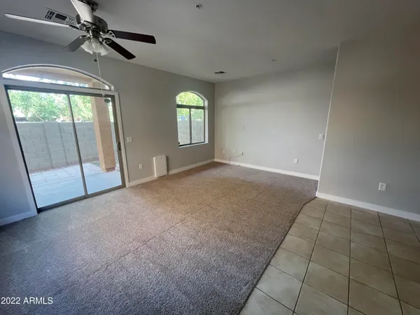 an empty room with windows and fan