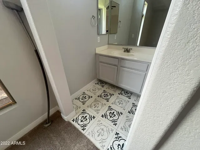 a bathroom with a sink and mirror with window
