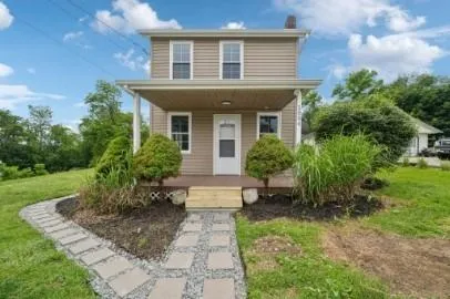 a front view of a house with a yard and potted plants