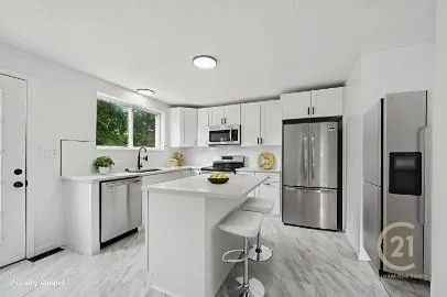 a kitchen with stainless steel appliances granite countertop a refrigerator sink and stove