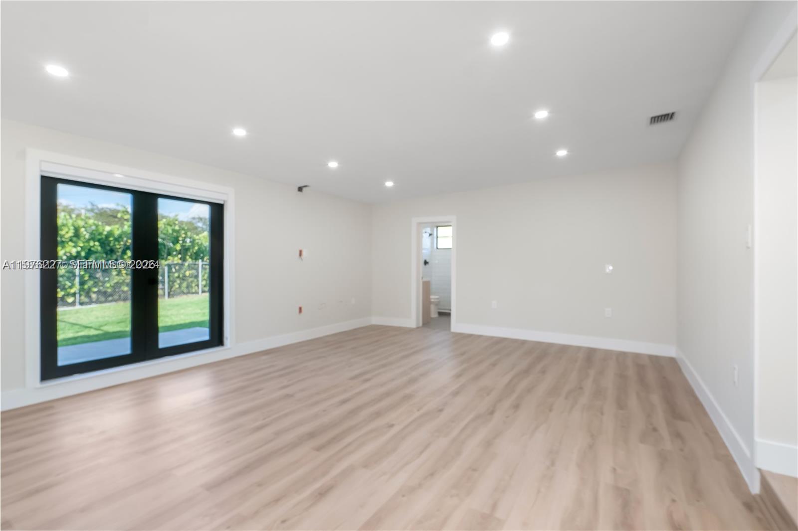 8421 Southwest 27th Terrace Miami, FL 33155 - Photo 16 of 22 an empty room with wooden floor and windows