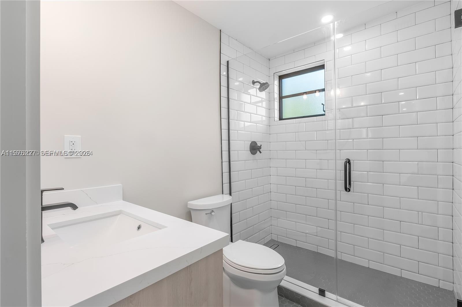 8421 Southwest 27th Terrace Miami, FL 33155 - Photo 4 of 22 a bathroom with a toilet a sink a shower and mirror