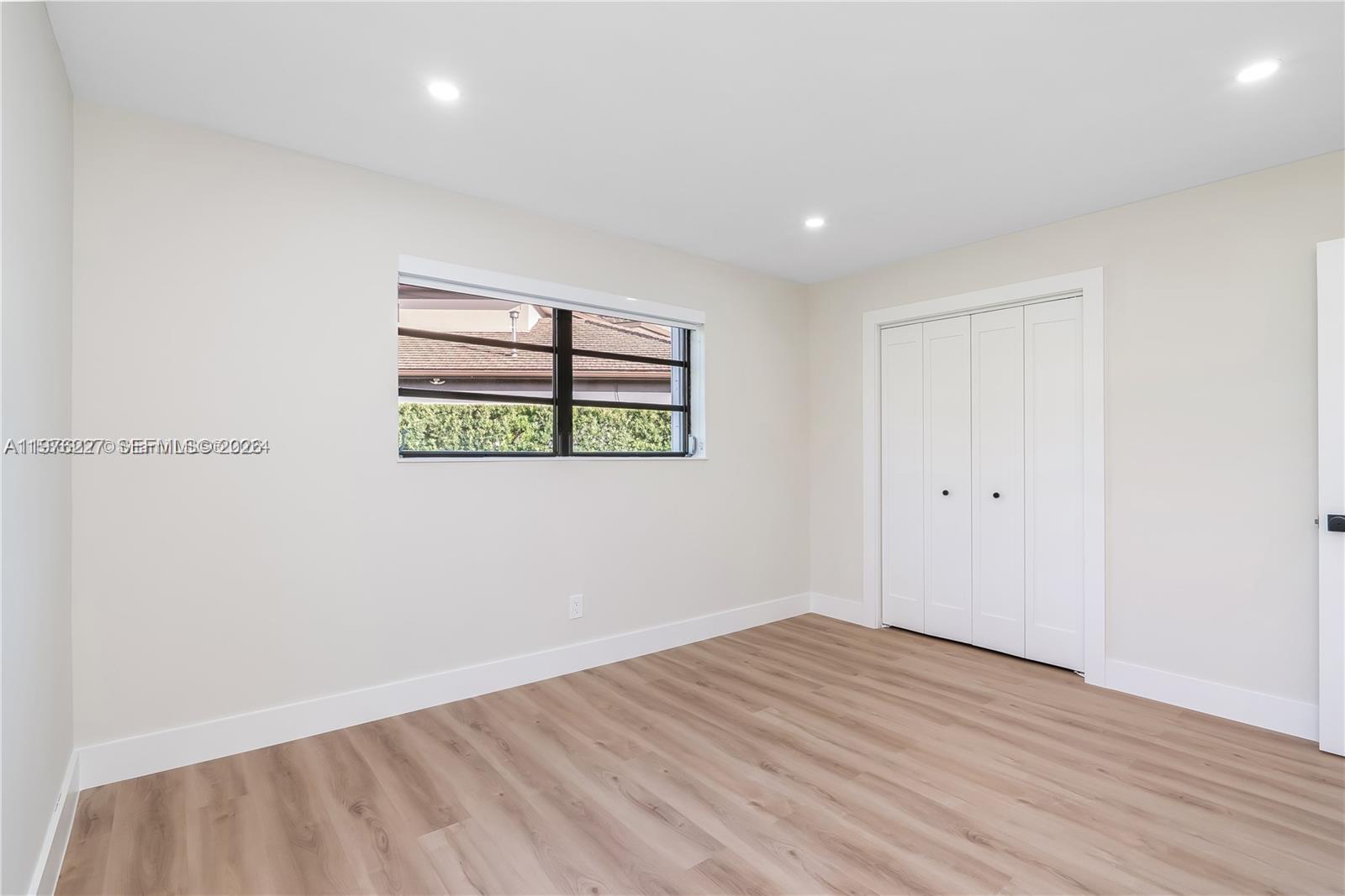 8421 Southwest 27th Terrace Miami, FL 33155 - Photo 7 of 22 an empty room with wooden floor and window