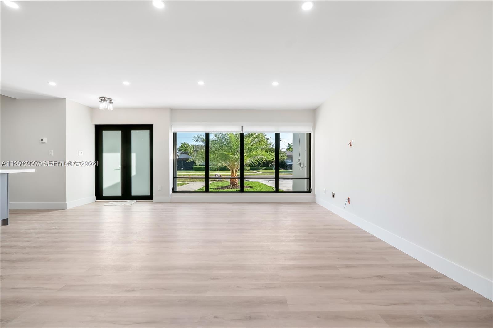 8421 Southwest 27th Terrace Miami, FL 33155 - Photo 8 of 22 a view of an empty room with wooden floor and a window