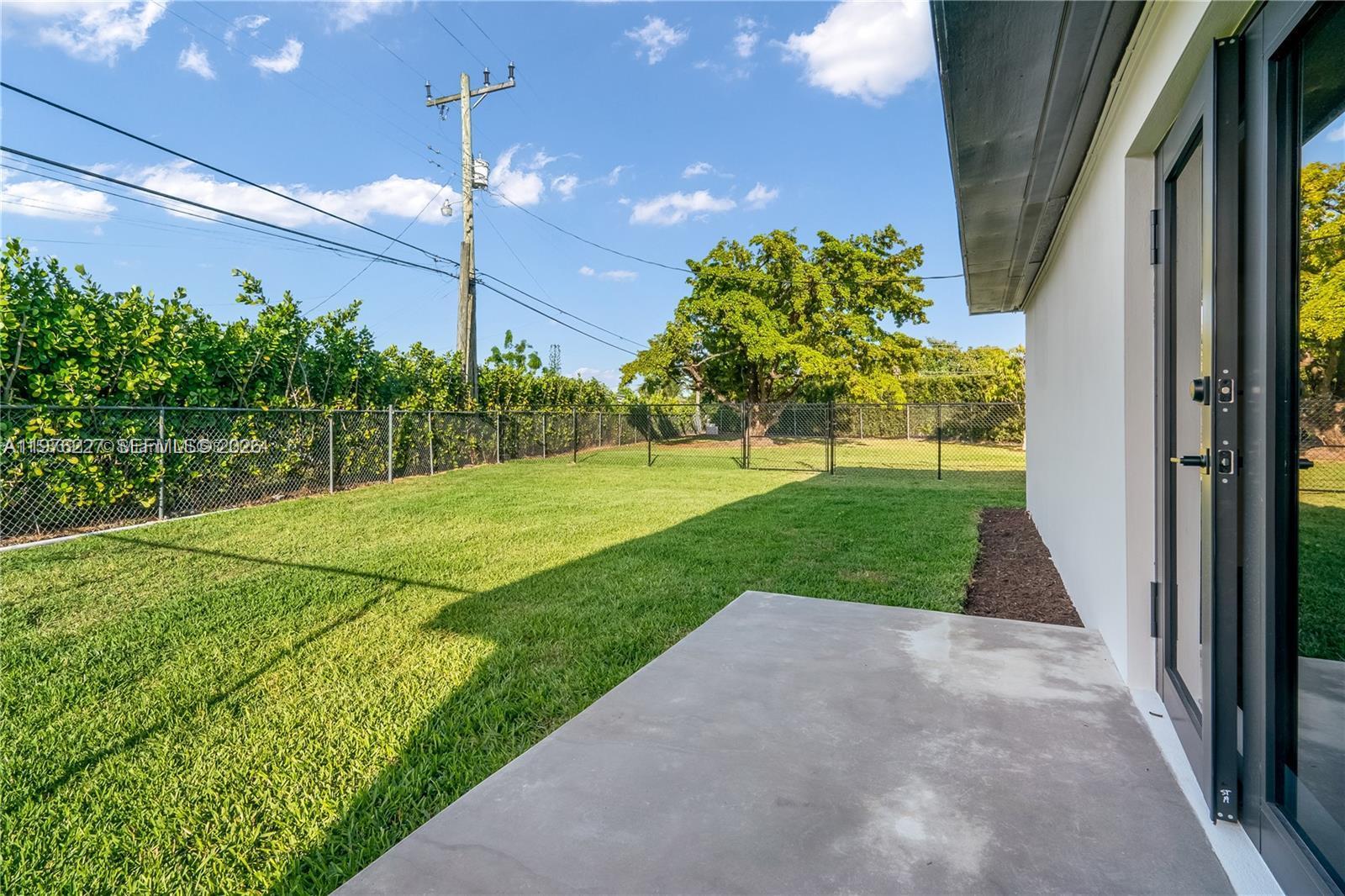 8421 Southwest 27th Terrace Miami, FL 33155 - Photo 10 of 22 a view of a back yard with flower plants and wooden fence