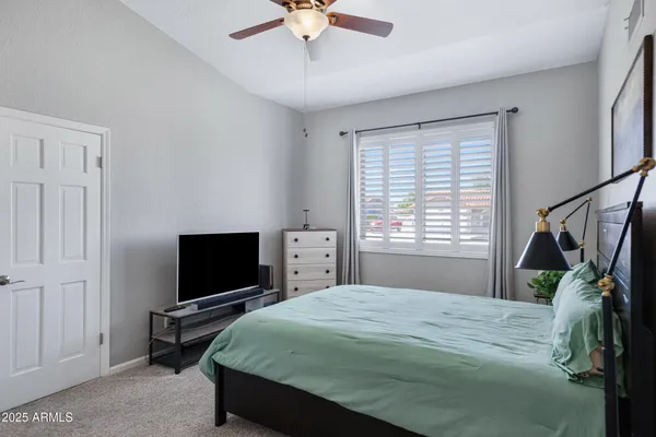 a spacious bedroom with a bed and a chandelier
