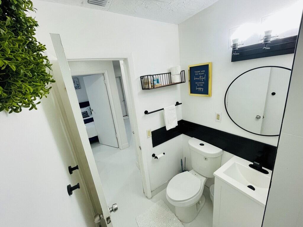 5537 Southwest 6th Street Margate, FL 33068 - Photo 27 of 40 a bathroom with a toilet sink and mirror